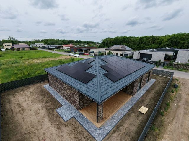 Saulės elektrinė ant modernaus vienaaukščio namo keturšlaičio stogo